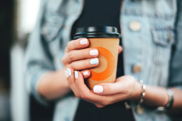 hands holding a cup with Hotshop logo on it